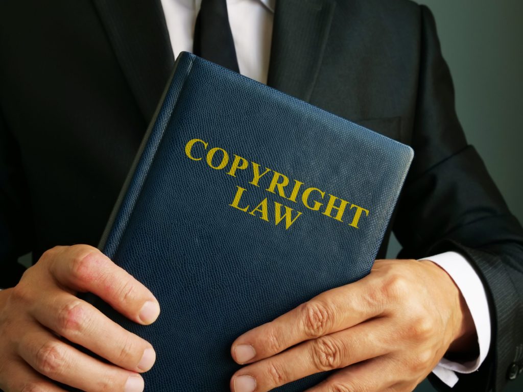 Man Holding Copyright Law Book In Hands